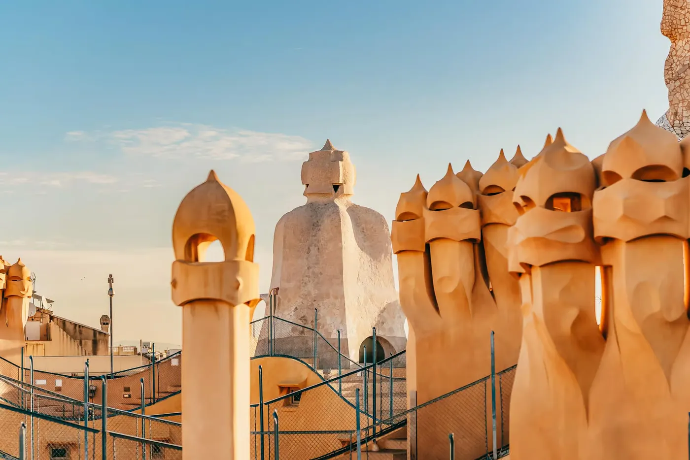 Sculpted rooftop chimneys and roof terraces in early daylight.